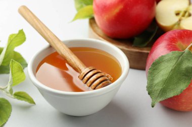 Tatlı bal ve taze elmalar beyaz masada, yakın plan.