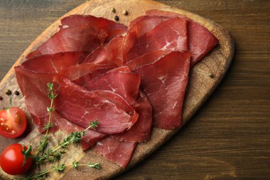 Lezzetli bresaola, biber, domates ve kekik ahşap masa, üst manzara