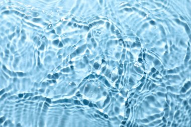 Açık mavi arkaplanda açık suyun dalgalı yüzeyi, üst görünüm