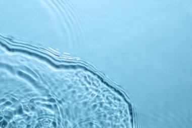 Açık mavi arkaplanda açık suyun dalgalı yüzeyi, üst görünüm