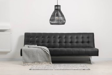 Oturma odasında gri battaniyeli rahat bir kanepe