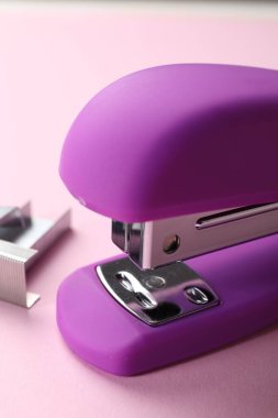 Pembe arka planda zımbaları olan parlak zımba, yakın plan.