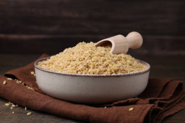 Masada çiğ bulgur ile kase ve kepçe, yakın plan.