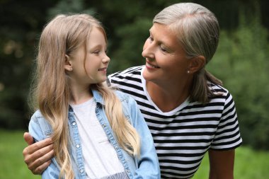Torunuyla birlikte parkta vakit geçiren mutlu bir büyükanne.