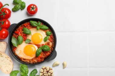 Lezzetli Shakshuka beyaz fayanslı masada servis edilir. Metin için boşluk