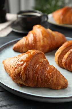 İçerideki karanlık masada enfes taze kruvasanlar, yakın plan.