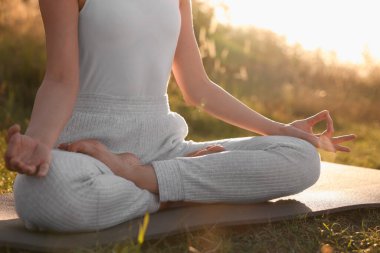 Dışarıdaki yoga minderinde Padmasana egzersizi yapan kadın, yakın plan. Lotus pozu