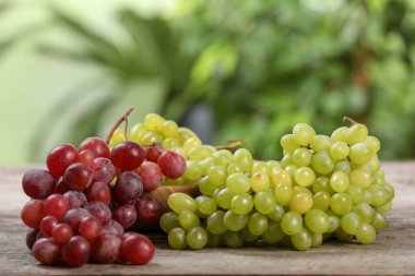 Tahta masadaki farklı olgun üzümler bulanık arkaplan, metin için yer