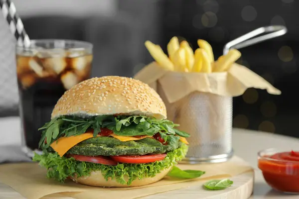 Tasty vegetarian burger served with french fries and soda drink on white table, closeup. Space for text