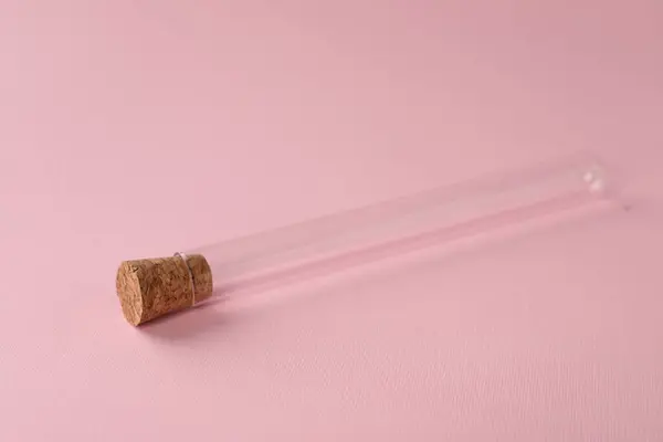 Test tube on pink background. Laboratory glassware