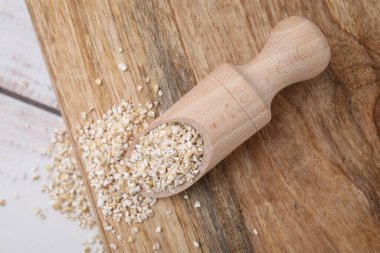 Çiğ arpa kepçesiyle hafif ahşap masada homurdanıyor.