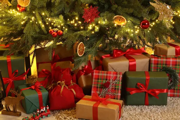 Odada Noel ağacı altında birçok hediye kutuları