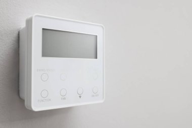 Beyaz duvarda bir termostat, yakın çekim ve metin için boşluk. Akıllı ev sistemi