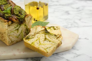 Beyaz mermer masada fesleğenli taze pişmiş pesto ekmeği, yakın plan. Metin için boşluk