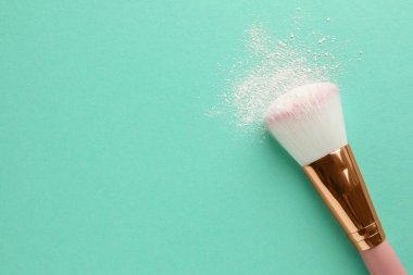 Turkuaz arka planda pirinç aromalı makyaj fırçası, üst manzara. Metin için boşluk