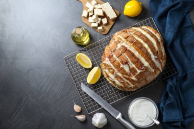 Taze pişmiş ekmek, tofu peyniri, malzemeler ve siyah masa üzerinde bıçak, düz yatak. Metin için boşluk