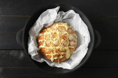Taze pişmiş ekmek tofu peyniri ve limon aromalı siyah ahşap masa, üst manzara.