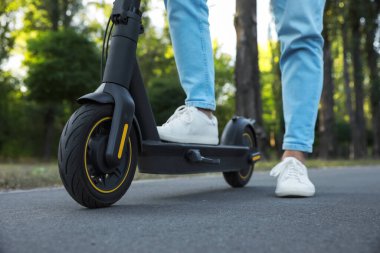 Parkta modern elektrikli scooter kullanan adam, yakın plan.