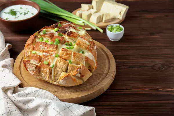 Taze pişmiş ekmek, tofu peyniri ve ahşap masada yeşil soğan. Metin için boşluk