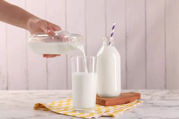 Γυναίκα Ρίχνει Γάλα Από Μπουκάλι Ποτήρι Λευκό Μαρμάρινο Τραπέζι Closeup — Φωτογραφία Αρχείου