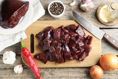 Çiğ sığır ciğeri ve ürünleri ahşap masaya koyun.