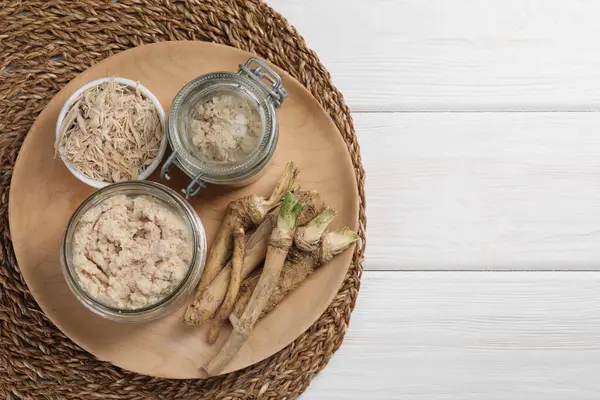 Lezzetli bir yaban turpu tabağı ve beyaz ahşap masaya kök, üst manzara. Metin için boşluk