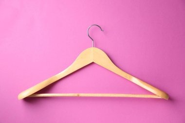 Parlak pembe arka planda boş ahşap askısı, üst görünüm