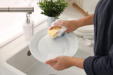 Mutfakta bulaşık yıkayan kadın, yakın plan.