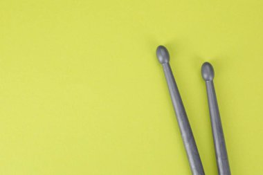 Açık yeşil arka planda iki gri baget çubuğu, üst manzara. Metin için boşluk