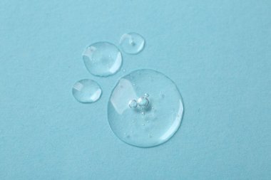 Açık mavi zemin üzerinde kozmetik serumu örnekleri, düz yatıyordu