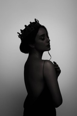 Açık gri arka planda taç giyen kadın silueti