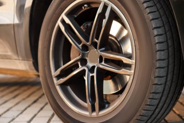 Dışarıdaki taş kaldırıma park etmiş büyük tekerli modern araba, yakın plan.