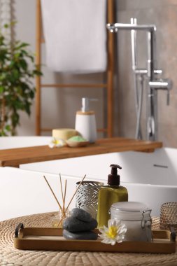 Banyodaki hasır masada farklı spa ürünleri ve güzel bir çiçek. Metin için boşluk