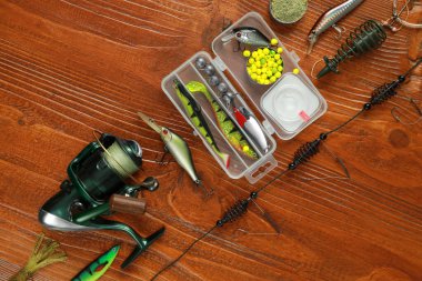 Fishing tackle on wooden table, flat lay clipart