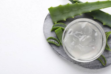 Aloe vera jeli ve beyaz arka planda bitki dilimleri, üst manzara. Metin için boşluk