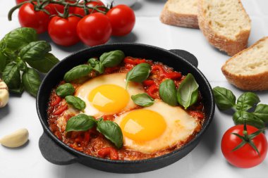 Lezzetli Shakshuka beyaz fayanslı masada servis edilir, yakın plan.