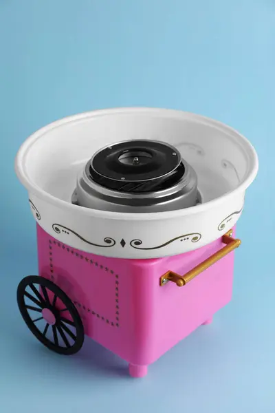 Portable candy cotton machine on light blue background