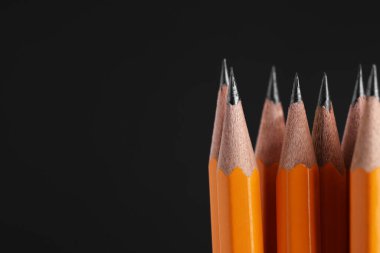 Siyah arkaplanda birçok grafit kalem, makro görünüm. Metin için boşluk