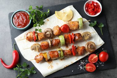 Gri masada servis edilen lezzetli şiş kebaplar.