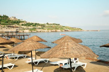 Deniz kıyısında şezlonglar ve plaj şemsiyeleri