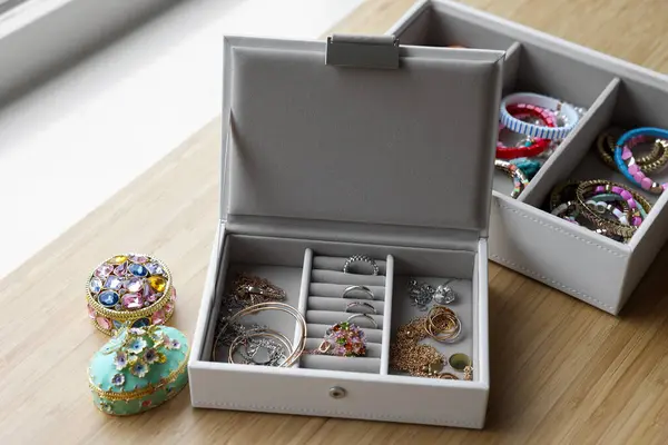 Jewelry boxes with many different accessories on wooden table