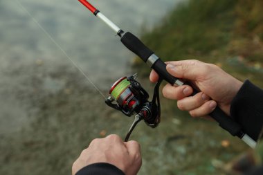 Nehir kenarında olta balıkçısı, yakın plan.