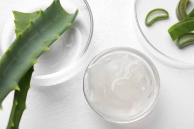 Aloe vera jeli ve beyaz zemin üzerinde bitki dilimleri, düz yatıyordu