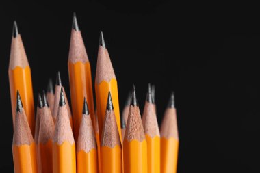 Siyah arkaplanda birçok grafit kalem, makro görünüm. Metin için boşluk