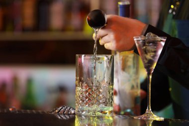 Barmen tezgahta taze alkollü kokteyl yapıyor, yakın plan.