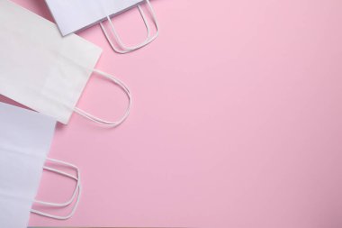 Pembe arka planda beyaz kese kağıtları, üst manzara. Metin için boşluk