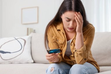 Evde kredi kartı olan stresli bir kadın, mesaj atmak için yeri var. Dikkatli ol, sahtekar.