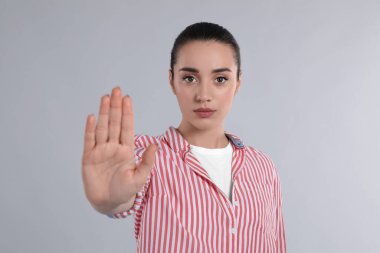 Açık gri arkaplanda hareket duruşu gösteren kadın