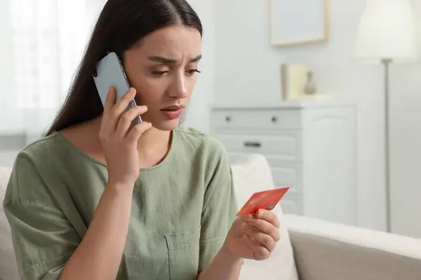 Zdezorientowana Kobieta Kartą Kredytową Rozmawiająca Przez Telefon Domu Uważaj Oszustwo — Zdjęcie stockowe