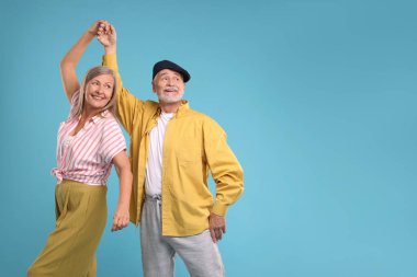 Üst düzey çift açık mavi arka planda dans ediyor, mesaj için yer var.